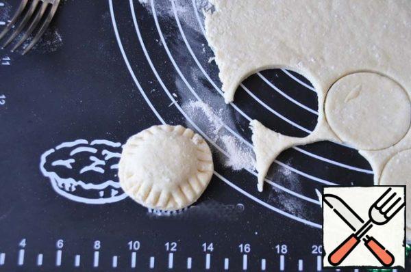 Cover with another circle of dough, secure the edges with a fork.
