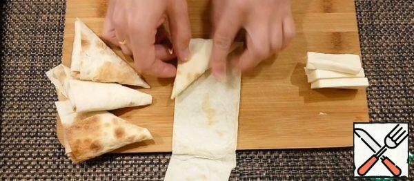 Wrap the cheese in pita bread in the shape of a triangle.
