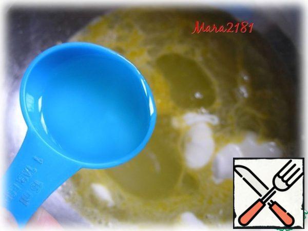 Meanwhile, heat the whey, add 50 g of sugar, 0.5 tsp salt, 2 eggs and 2 tbsp oil. Mix everything thoroughly until smooth.
