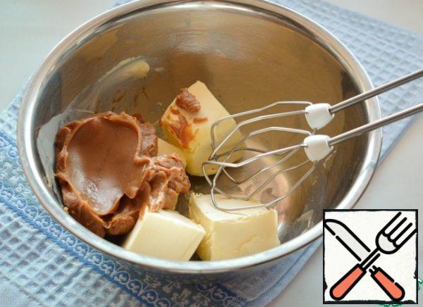 For the cream, whisk the soft butter with boiled condensed milk. In the middle of whipping, add cocoa and brandy.
