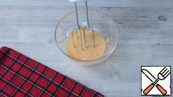 Soak the raisins in warm water. Add sugar to 1 egg and 2 yolks and beat until the mass turns white.
