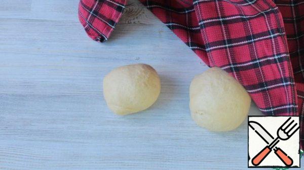 After proofing, divide the dough into parts. I have 1 large and 1 small part, since I have different shapes: a large one with a diameter of 14cm, a small one with a diameter of 9cm. Roll each part of the dough into a ball. Let stand for 10 minutes under a towel.
