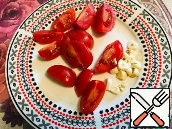 Cut tomatoes into 4 pieces, chop garlic.
