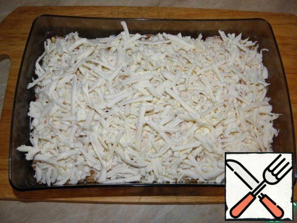 Next, a layer of slightly frozen cheese is also rubbed on a grater and distributed.
