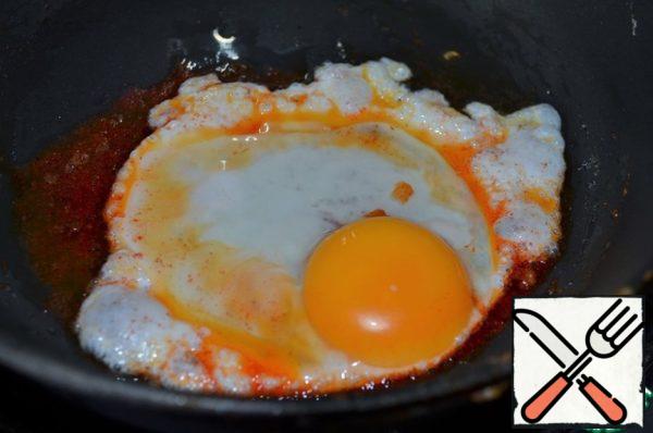 To serve, fry the "red" eggs.
To do this, put in preheated vegetable oil
1/2 tsp sweet paprika, fry two eggs in it one at a time.
Add the oil again, heat + the remaining paprika and fry two eggs. Add salt and flavored sauce to the yolks.