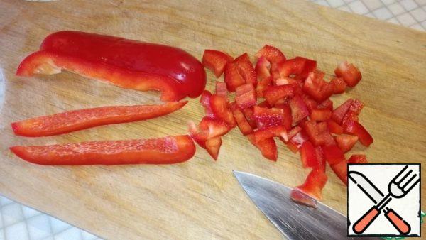 Peel the onion, wash and cut into small cubes, also chop the bell pepper.
