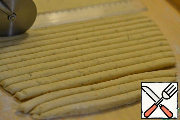With a sharp knife or a pizza knife, cut the dough into 24 strips.
