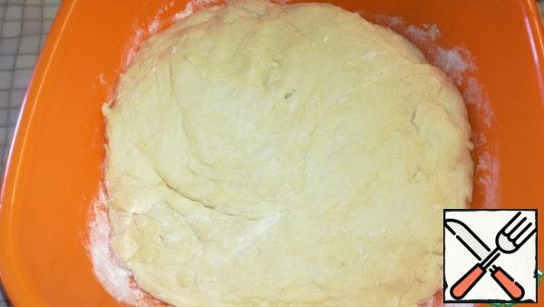 Slowly pour in the sifted flour and knead the dough. Cover and put away in a warm place for 40 minutes.
