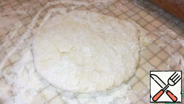 Sprinkle the surface of the table with flour and knead the dough a little.
