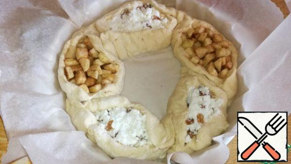Take a round baking dish. Cover with baking paper. And alternating the boats with the filling, lay out in a circle, forming a wreath. I made this wreath big, with a lot of filling.
