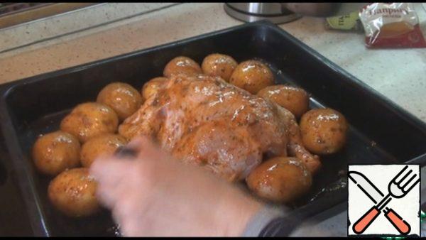 Wash the potatoes well, do not peel them and put them on a baking sheet. Wash the chicken, too, and put it on a baking sheet along with the potatoes. Melt the butter, add salt, any herbs or spices, paprika, crushed garlic, mix. We lubricate the chicken well with this mixture from all sides, inside and out, as well as potatoes. Bake in the oven at 180 degrees for 1 hour.
