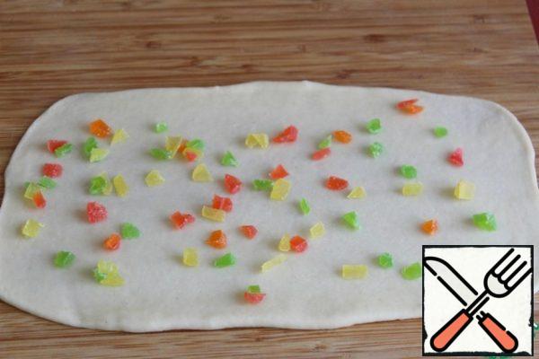 Divide the dough into 12 parts and roll each into a rectangle.
Sprinkle with candied fruits - I chop them finely.

