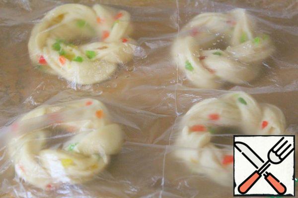 On a baking sheet covered with parchment, lay out the rings and brush each ring with the remaining melted butter, cover with a film - leave in a warm place for 20 minutes.
