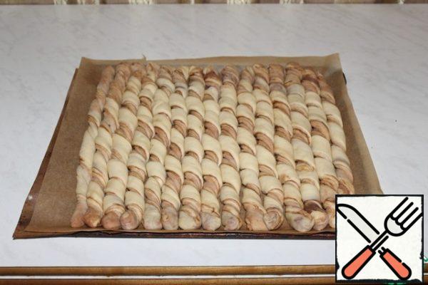 Spread on a baking sheet tightly to each other. Leave for 20 minutes for proofing.
