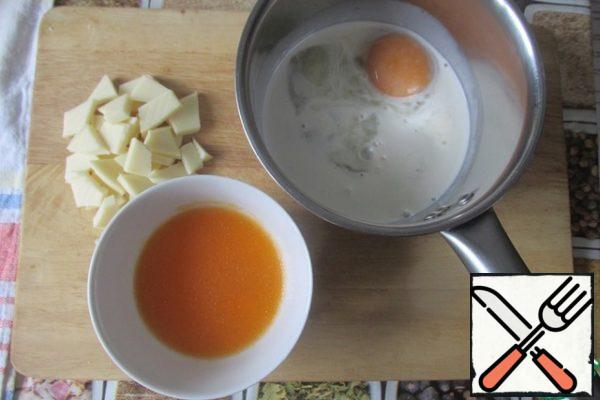Prepare the initial products.
I squeezed tangerine juice out of one large tangerine. And the juice and zest can be made from a slice of fresh orange. Break the chocolate into small pieces.
Gelatin is poured into the juice.
In a small saucepan, mix the yolk, vanilla sugar and 50 ml of cream. The remaining cream is removed for a while in the refrigerator.