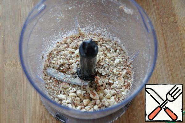 Dry the almonds in a frying pan and grind them into coarse crumbs with a rolling pin or a blender. Cut the raisins into 2-4 pieces and pour boiling water over them.
