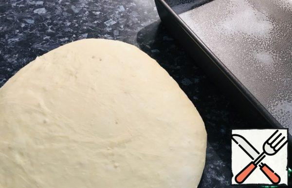 Pour flour on the cutting surface, lay out the dough, knead a little.
Grease a baking sheet with butter (I have 35 = 24)
