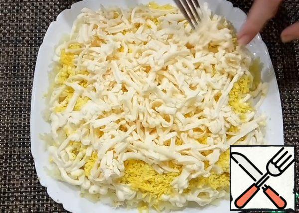 Grate the melted cheese on a coarse grater on top of the yolk. I pre-send the cheese to the freezer for 20-30 minutes, then it is easier to rub it.
