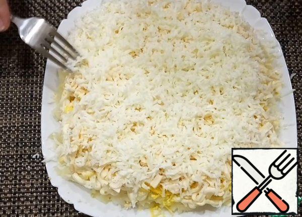 And the last layer is egg white. Grate it on a fine grater and spread it all over the salad with a fork.
