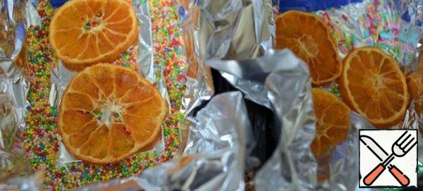 Prepare two molds by covering them with foil or food paper.
Pour a pastry sprinkle on the bag, I took a more suitable one for Easter, put a few rings of dried tangerine or other dried citrus.