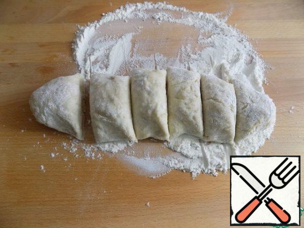 Let's form a "bar" and visually divide the dough with a knife into equal pieces, from which we will continue to form flower buns. I have a "candy bar" divided into 6 parts.
