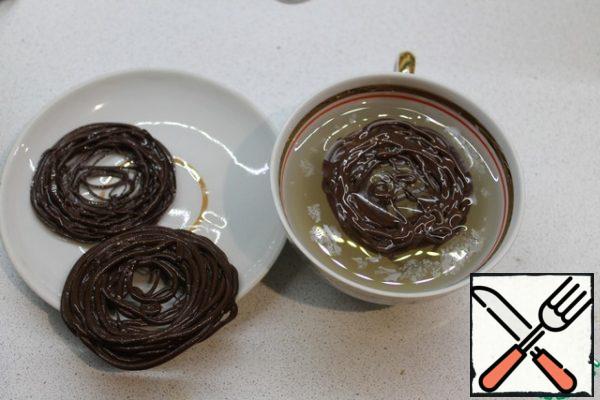 For chocolate nests, the chocolate should be melted, put in a bag and cut off a small corner. Vodka is pre-cooled in the freezer so that it is icy. Then pour it into a mold suitable in diameter for the top of your Easter, and quickly squeeze the melted chocolate in a circle right into it. Take out the nests and let them dry.
