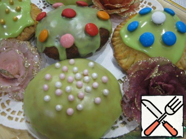 Decorate the cooled donuts with icing, sugar balls and candy drops.