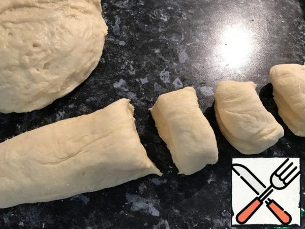Cut into two parts, one part of the roll "sausage" cut into flat parts.
Do the same with the second part, form rolls weighing 45-50grams. Dilute the egg yolk with a small amount of milk, brush the buns.
