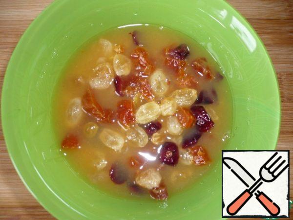 Pour the raisins, dried cranberries and chopped dried apricots with orange juice and leave them to soak well.
