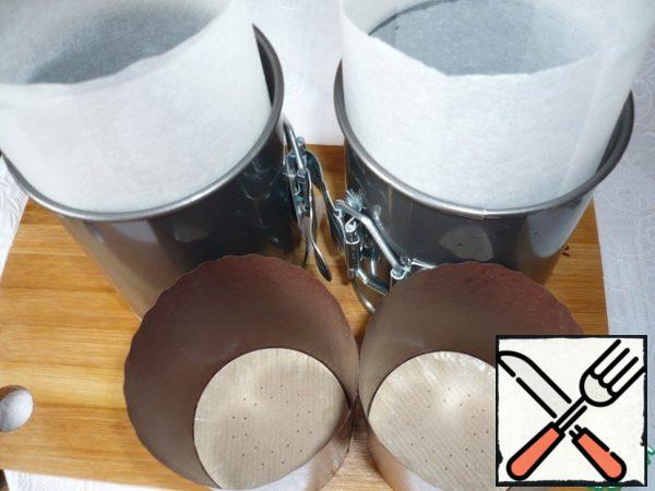 Prepare the cake molds: I have two removable molds d - 10 cm and h - 11 cm, as well as two paper molds d - 7 cm and h - 8.5 cm. Cover the detachable molds with parchment paper (sides and bottom), grease the parchment paper with vegetable oil.
