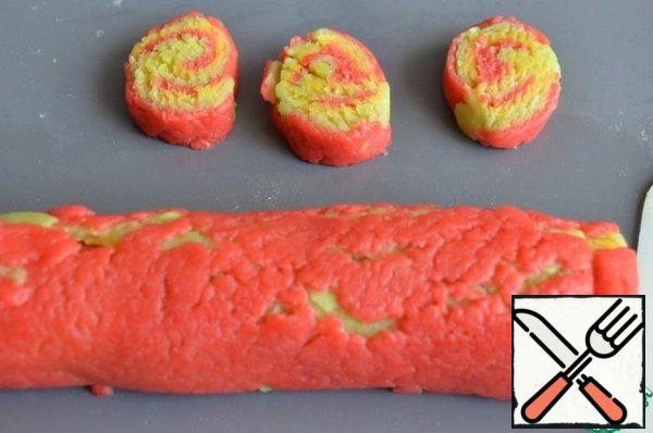 Trim the edges and roll the roll.
Cut into strips to shape the eggs.
In this way, form all the cookies, swapping the colored dough.
