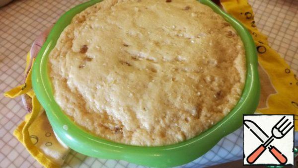 After the time has elapsed, knead the risen dough. Prepare the molds for the cakes, fill them with a ready-made dough for 1/3. Cover the dough form with a towel and let it rise in a warm place.

