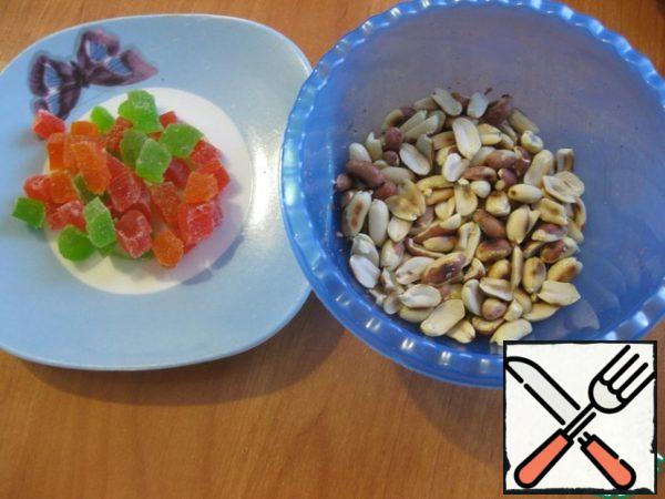 Now divide this mass into three equal portions - pour into a convenient dish for whipping. Add a packet of vanilla sugar to the white part, whisk again, set aside. Pre-prepare the filling - fry the nuts and chop the candied fruits.
