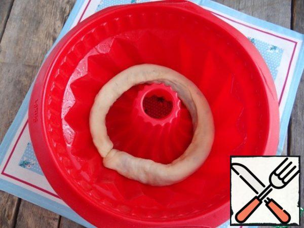 Lubricate the silicone mold with vegetable oil. I put the rolls with stuffing in the mold. I use a mold with a diameter of 22 cm.
