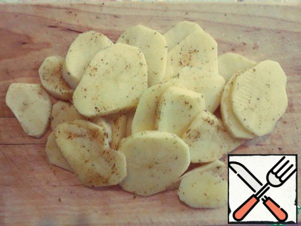 Prepare the potatoes. Wash, clean, cut into circles of about 5 mm. The main thing is not subtle, so that the potatoes do not fall apart. Sprinkle with salt, pepper, mix well with your hands so that all the circles are in spices. I had potato seasoning.
