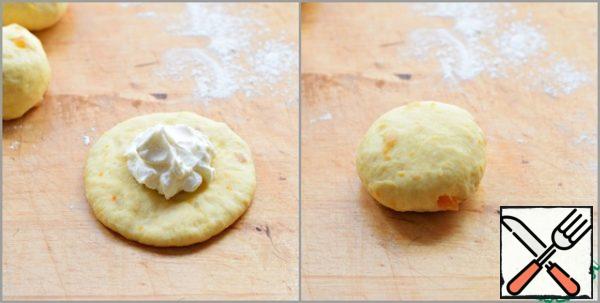 We roll out each blank into a circle about 1 cm thick .
Put a teaspoon of filling in the center of the circle, mold the edges, forming a bun.
