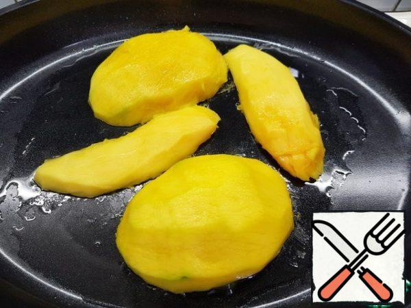 Preheat the pan to a temperature above average and brush with sunflower oil.
Fry the mango from the cut side (grate the slices) for 5-6 minutes.
