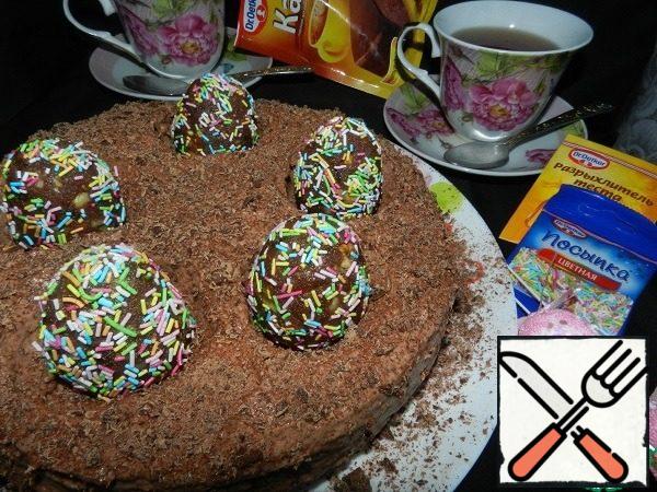 Sprinkle the cake with chocolate chips on top. We will insert an egg into each nest.
Let the cake soak. Leave it in a warm place for a couple of hours, and then put it in the refrigerator, preferably overnight.
