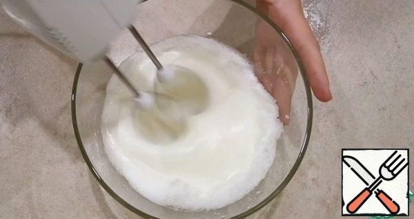 Divide the eggs into yolks and whites. Add a pinch of salt to the whites and whisk until light peaks form.
Then add 1/4 of the sugar and continue to beat until strong peaks form.
