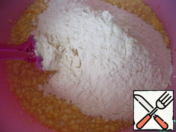 Add the flour, but not all at once, but more than half and knead the dough in a bowl with a spatula.
