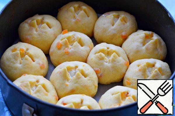 Place the rolls in a form lined with parchment. The diameter of the mold is 20-22 cm .
On each bun (in the center) make a shallow (to the filling) cross-shaped incision. (cooking scissors or sharp knife)
Cover the mold with a napkin or a thin towel and put it in the heat for 15-20 minutes.