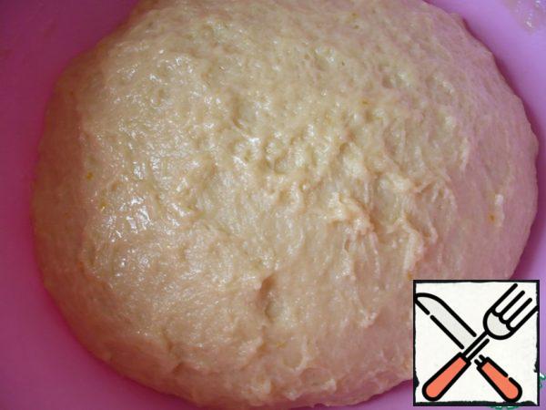 The dough turns out to be of medium consistency, not very dense. Lubricate the bowl with the dough with vegetable oil, cover with cling film and put in a warm place.

