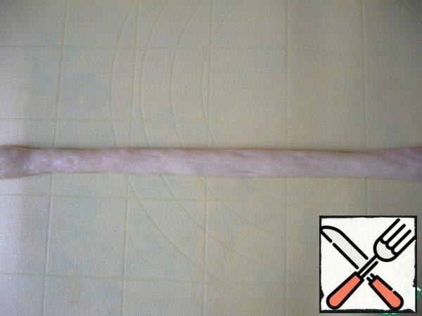 Lie down so that the dough has rested and even slightly fits. Now it will be easy to roll it out to the desired length. Roll out each flagellum, pressing it to the table, without stretching (so that it does not stretch), of the same length ~ 30 cm. From the tip of the flagellum, make it thinner.

