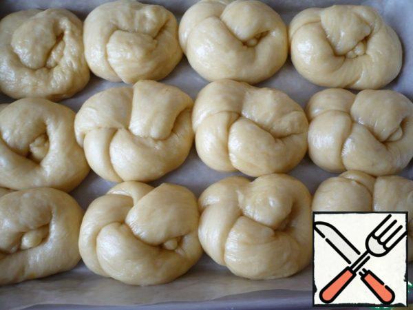 Now we put the prepared buns in a mold at the same distance from each other. Cover the rolls with cling film and send them to a warm place.
