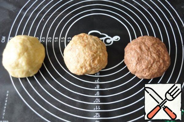 Knead a soft elastic dough, gradually add flour, do not clog the dough with flour. Divide the dough into three equal parts. Leave one part white, without additives, add cinnamon to the other, cocoa to the third. Knead the dough, put it in the refrigerator for 30 minutes.
