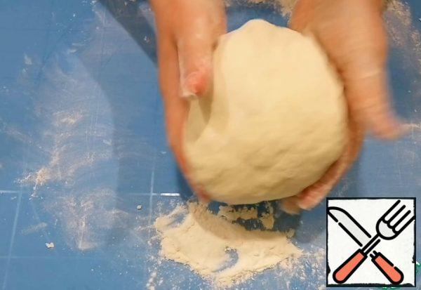 Gradually add the flour, stirring with a whisk.
Knead the dough on the table, it should not be tight.
