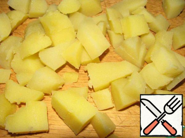 Wash the potatoes and cook in the peel for 25 minutes. Drain, cool, peel and cut into cubes.
