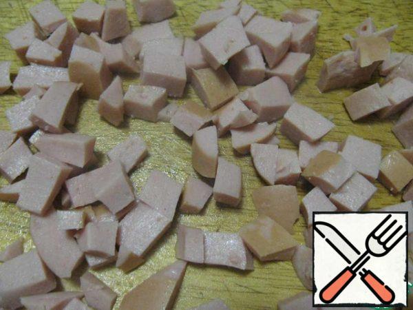 Cook the sausages, cool and cut into small cubes.
