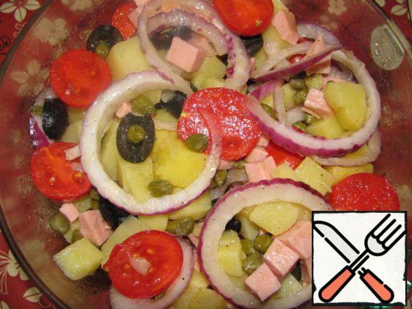 Add tomatoes, olives, sausages and onions to the salad bowl.
