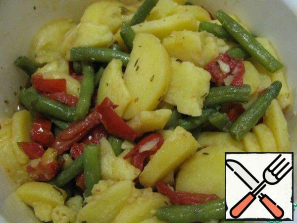 Mix the chopped potatoes, beans and tomatoes and pour in the remaining bean broth and vinegar. Leave to marinate for 20 minutes.
